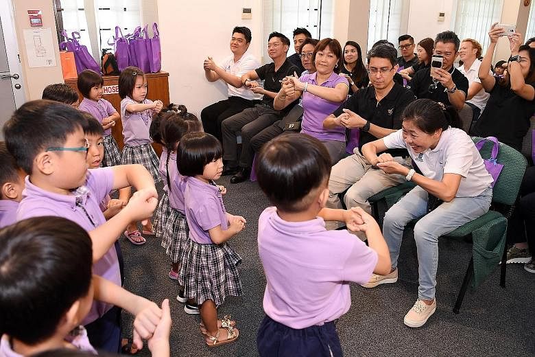 From right: RAS president Tan Puay Hoon, Associate Professor Muhammad Faishal Ibrahim and Ms Brands Ng, director of Cherie Hearts @ Charlton, joining in as the pre-schoolers put on a performance, showing how to wash their hands properly.