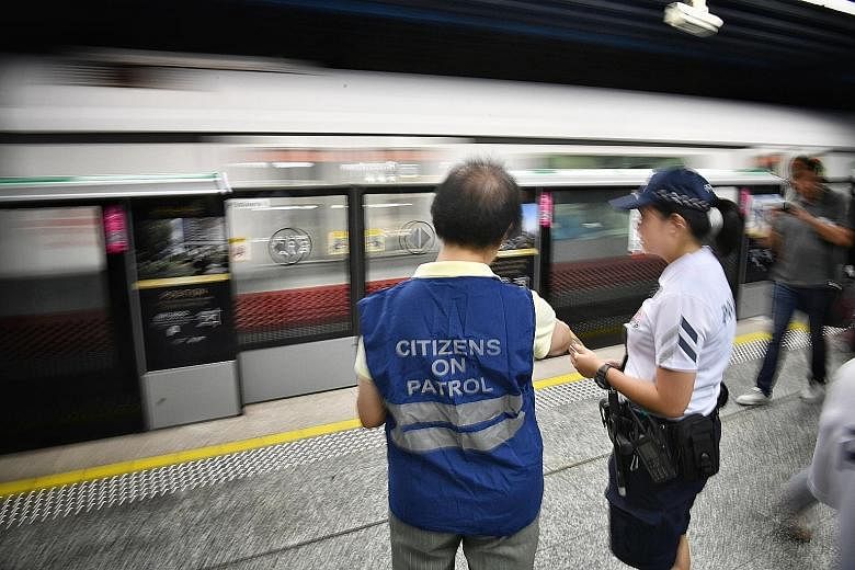 Citizens On Patrol (COP) volunteer Lucy Toh patrolling Queenstown MRT station last Friday, accompanied by a police officer. For a start, volunteers will be accompanied by police officers during their patrols in MRT stations and they will walk along t