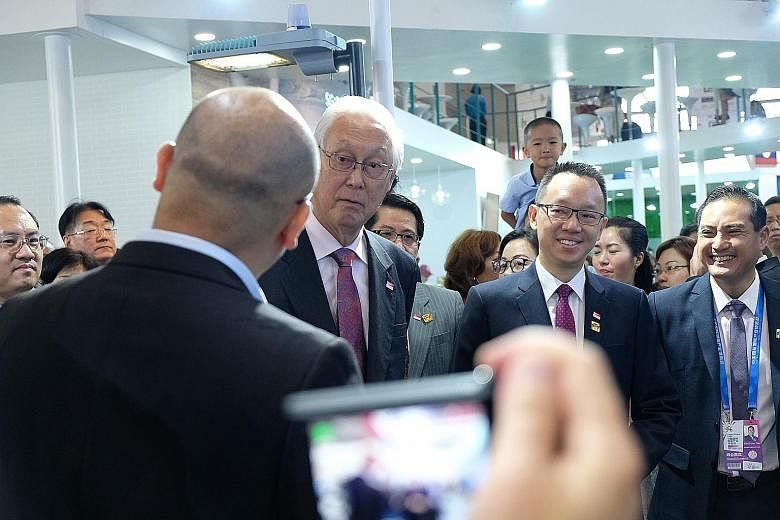 Emeritus Senior Minister Goh Chok Tong and Senior Parliamentary Secretary for Trade and Industry and Foreign Affairs Tan Wu Meng (second from right) on a tour of the Singapore pavilion at the Smart China Expo in Chongqing yesterday.