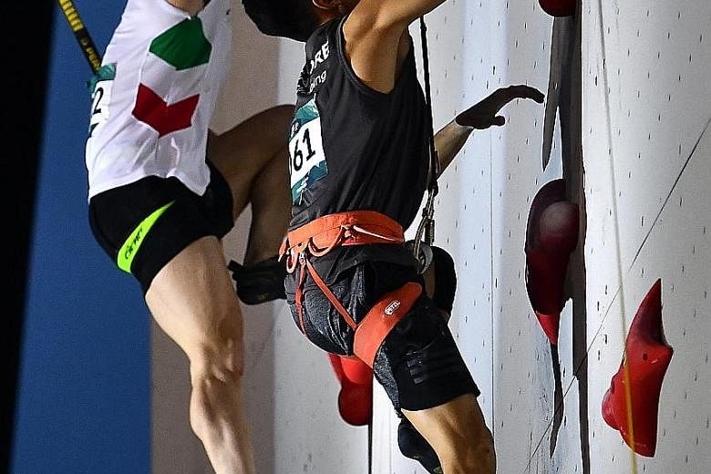 Singapore's Amar Hassan (right) finding Reza Alipour, the eventual champion, a tough customer in the round of 16 of the speed climbing competition at the Jakabaring Sport Centre yesterday.
