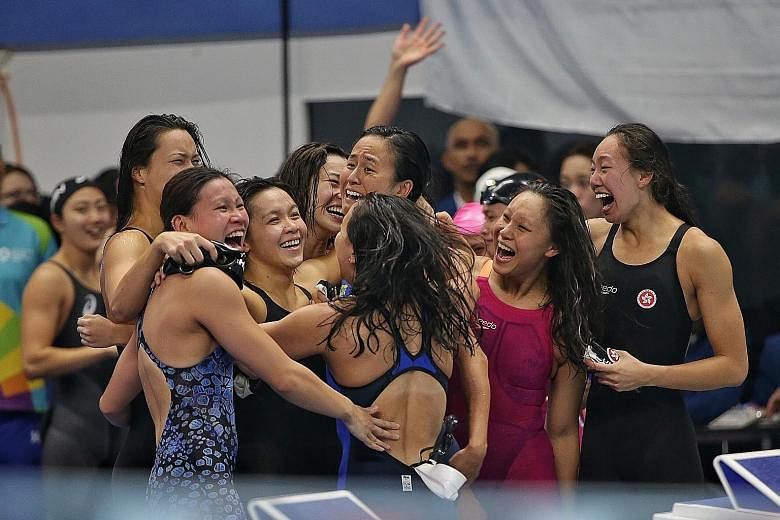 Left: Roanne Ho benefited after a fellow swimmer was disqualified, leaving her second in the 50m breaststroke at the Gelora Bung Karno Aquatic Centre in Jakarta. Below: The 4x100m medley relay teams from Hong Kong and Singapore embrace one another af