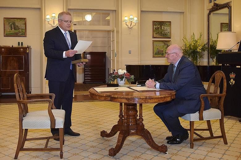 In a leadership twist that ended days of political uncertainty in Australia, former immigration minister Scott Morrison (standing) emerged the surprise winner yesterday in a three-way challenge for the top post in the ruling Liberal Party. He won the