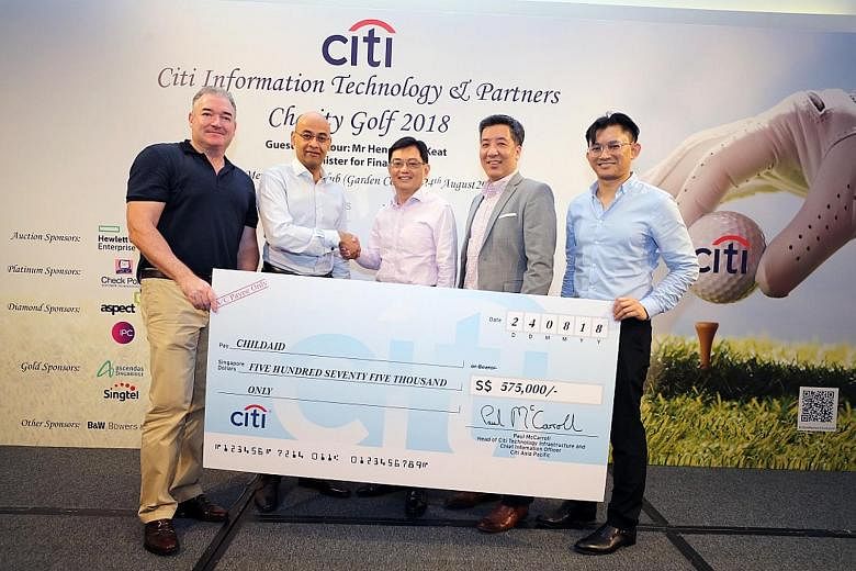 Finance Minister Heng Swee Keat, (centre) at the cheque presentation with (from far left) Mr Paul McCarroll, Mr Amol Gupte, Mr Marc Lim and Mr Helmi Yusof.
