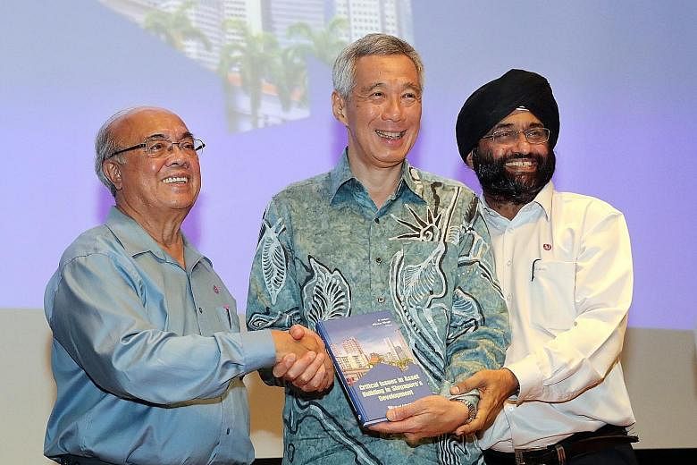 Prime Minister Lee Hsien Loong at the launch yesterday of a book edited by Associate Professor S. Vasoo (left) and Associate Professor Bilveer Singh. The book examines Singapore's asset-building policies through a series of essays, which look at trad