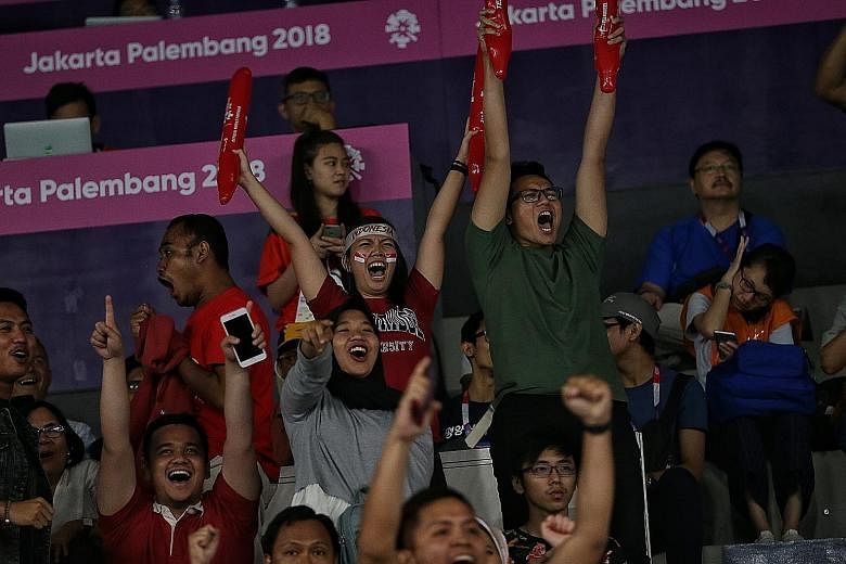 To say badminton is like a religion to Indonesians would not be an understatement. The home crowd was in full voice yesterday as supporters like Evangeline Launy (with Indonesia flag stickers on her cheeks) and Guntur Syayidu (in green) cheering thei