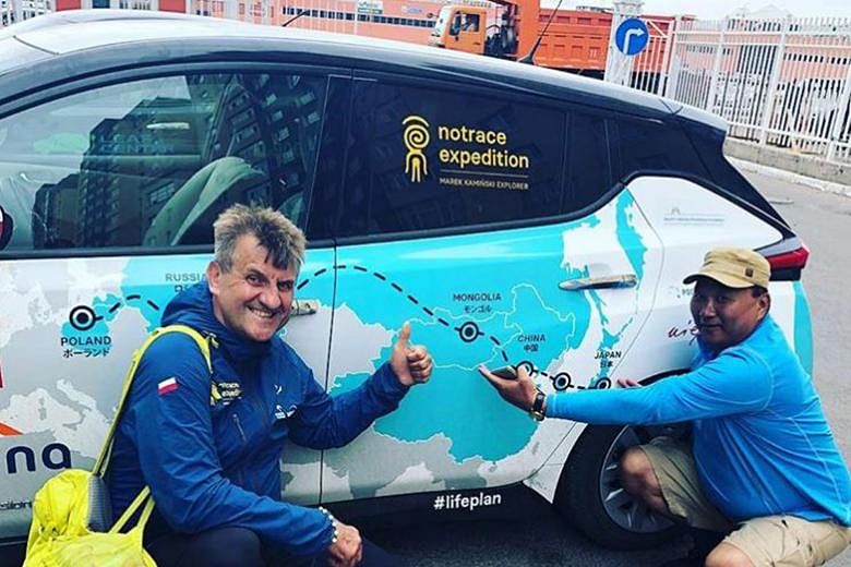 Mr Marek Kaminski with the Nissan Leaf vehicle he has been travelling in and a Mongolian he met during his drive. His stop in Japan marked the halfway point of his 32,000km No Trace Expedition.
