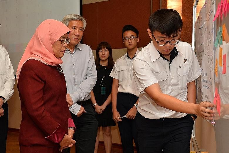 Anglo-Chinese Junior College student Dingwan Chenxi, 17, presenting his group's ideas on preventing racial stereotypes to President Halimah Yacob yesterday. The students were taking part in a racial harmony programme at the Singapore Discovery Centre