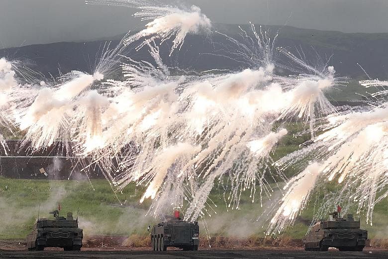 Battle tanks from Japan's Ground Self-Defence Force firing smoke rounds during a live-fire exercise at a training area in Gotemba, Shizuoka prefecture, last Saturday. In the White Paper released yesterday, the Japanese Defence Ministry pointed to mor