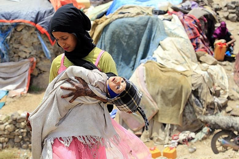A Yemeni girl with her infant sister outside temporary shelters at a camp for internally displaced persons on the outskirts of Sanaa last week. A UN report has found that "coalition air strikes have caused most of the documented civilian casualties" 