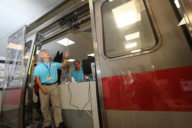 Associate Professor Ling Keck Voon from the Nanyang Technological University pointing to a train door sensor system at the SMRT-NTU Smart Urban Rail Corporate Laboratory.