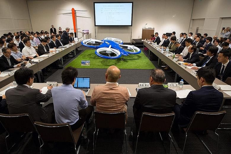 Transportation company executives meeting Japanese officials at the launch of the flying car project yesterday. Japan wants to draw up a road map by the end of the year to commercialise flying cars.