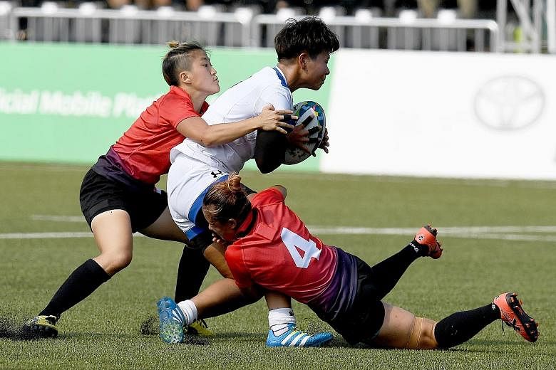 Jayne Chan (far left) and Eunice Chu tackling a South Korean. Chan played just five minutes but scored the winning try for Singapore's 22-17 Group A victory.