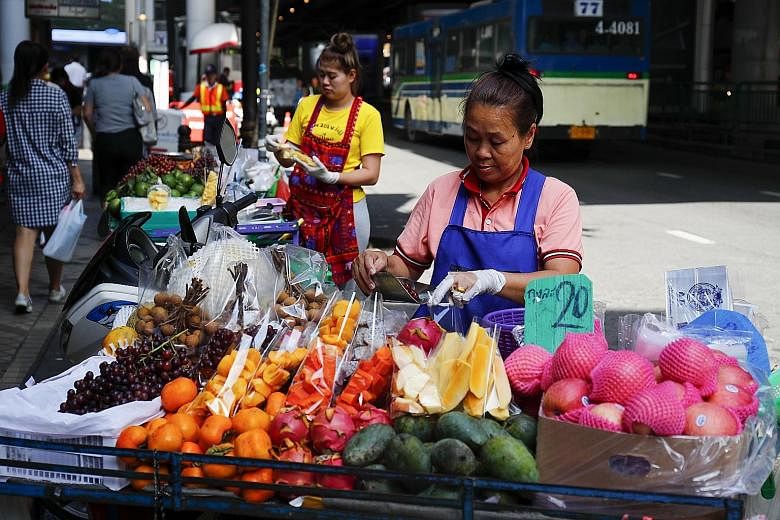 Street vendors tending to their stalls in Bangkok. Thai households are among the biggest borrowers in Asia and private consumption accounts for half of Thailand's $669 billion gross domestic product. Debtors could feel more pain as the Thai central b