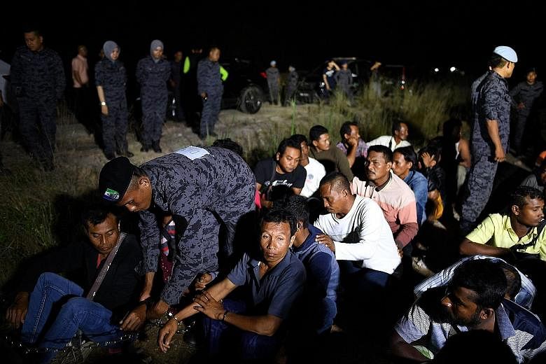 Immigration officers detaining foreigners at a raid last year. Malaysia says it will not extend the amnesty deadline for illegal foreign workers.