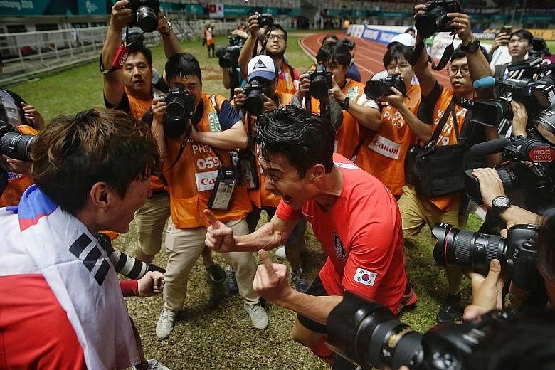 South Korea's Son Heung-min (right) and Hwang Ui-jo celebrating after winning the Asian Games football final yesterday. MORE ASIAN GAMES REPORTS SPORT A26-28