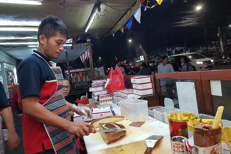 A worker at Martabak 65a in Jakarta applying butter on top of a freshly cooked sweet murtabak. Rich chocolate min jiang kueh-style pancake from Martabak Markobar in Indonesia.