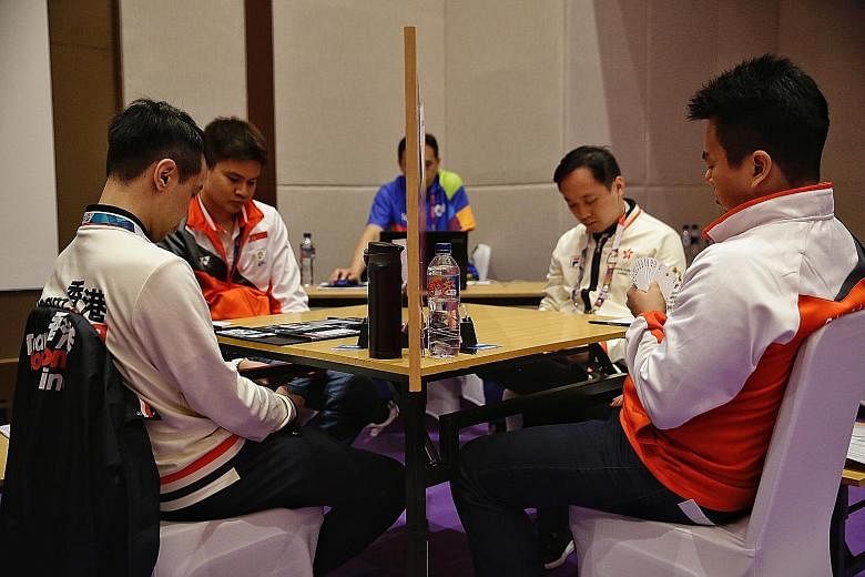 Poon Hua (right) and Loo Choon Chou (second from left) on their way to the Asian Games bridge men's team gold for Singapore against Hong Kong on Aug 27. The duo are professionals unlike their four team-mates.