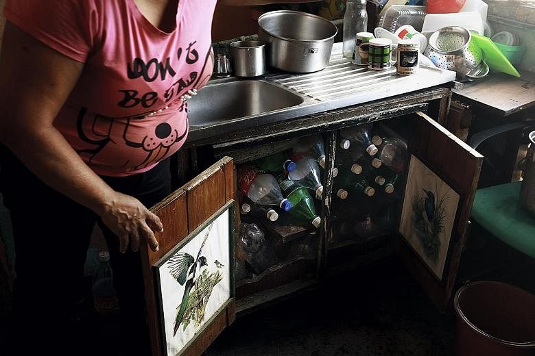 Bottles used to collect water are stored under a sink in a Caracas flat. A man-made drought is leaving residents from all social backgrounds in Venezuela without water.