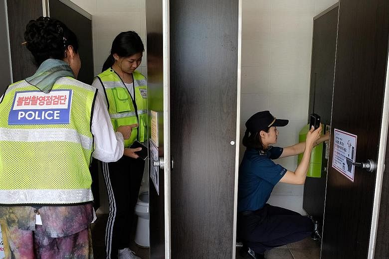 A spy-camera search squad inspecting a public toilet near a swimming pool in Changwon, South Korea.