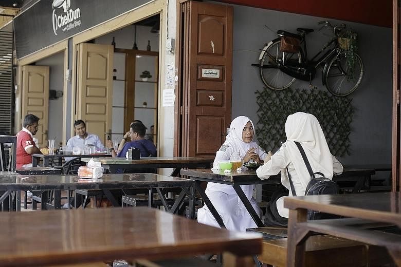 Diners at a restaurant in Bireuen district. An Aceh official says banning men and women, who are not married or related, from sharing a table at eateries would help women be "more well-behaved".