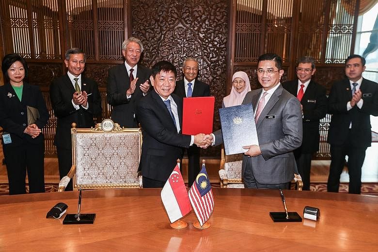 Singapore's Coordinating Minister for Infrastructure and Minister for Transport Khaw Boon Wan and Malaysia's Economic Affairs Minister Mohamed Azmin Ali at the signing ceremony at the Malaysian Prime Minister's Office in Putrajaya yesterday. With the