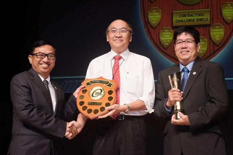 LTA chairman Alan Chan presenting the Contractors Challenge Shield to Shanghai Tunnel Engineering Co (Singapore)'s workplace safety and health manager Thant Zaw (left) and project director Khor Eng Leong.