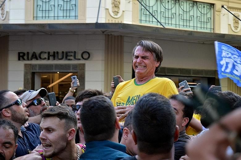 Mr Jair Bolsonaro (above) reacting after being stabbed in the abdomen during a rally in Juiz de Fora, Brazil, on Thursday. In a screen grab (left), the knife can be seen.