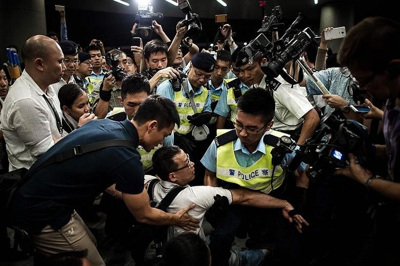 Police removing protesters from the Legislative Council grounds in a file photo taken on June 14, 2014. Hong Kong's Court of Final Appeal yesterday freed the 13 pro-democracy activists who stormed the place.