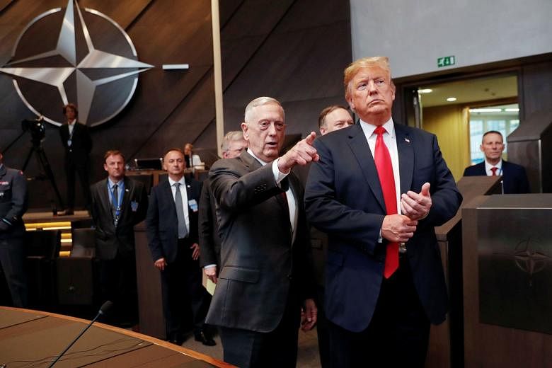 US President Donald Trump with Defence Secretary James Mattis as they arrived for a meeting of the North Atlantic Council in Brussels in July. Top US officials have denied they authored an anonymous New York Times op-ed detailing an "internal resista