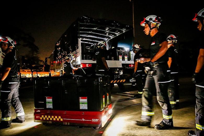 Above left: A Singapore Civil Defence Force officer from the Operation Lionheart contingent operating a semi-autonomous load-carrying transporter during the 36-hour exercise that began last Wednesday. Above right: Officers working to equip tents acco