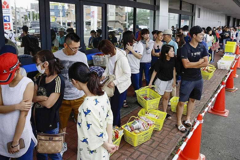 People lining up to buy foods outside a store after an earthquake hit the area in Sapporo, Hokkaido, northern Japan. In a display of renowned resilience, orderly queues formed outside convenience stores and supermarkets that remained open, with stoic