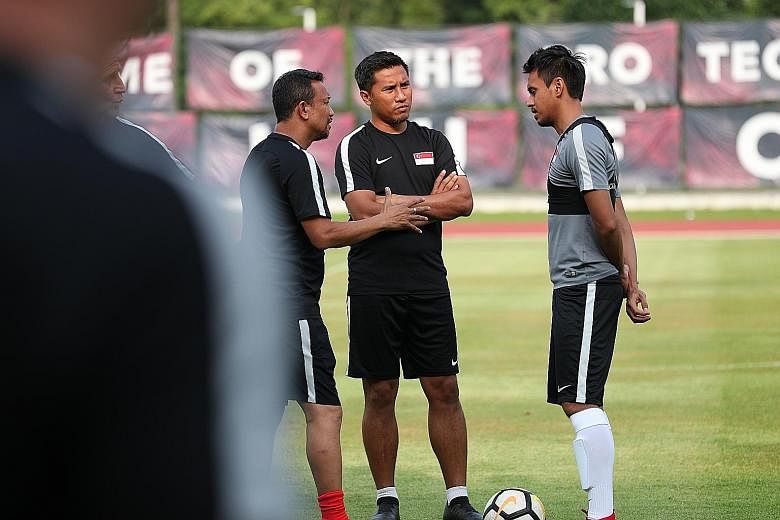 Singapore national football team head coach Fandi Ahmad and his player mentor Noh Alam Shah (centre) give midfielder Shahdan Sulaiman some advice during a Lions training session at Bishan Stadium.