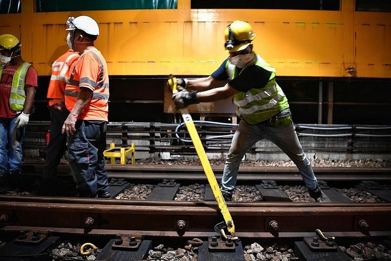 Members of the engineering team making the 300m walk from Boon Lay station to reach the maintenance work site. An engineering train used to transport the rails, along with other equipment and materials required for the replacement works, was on site.