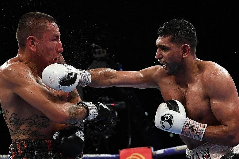 Britain's Amir Khan (right) using his famed hand speed against Colombia's Samuel Vargas in their welterweight bout on Saturday, en route to his 119-108, 119-109, 118-110 unanimous-decision victory.