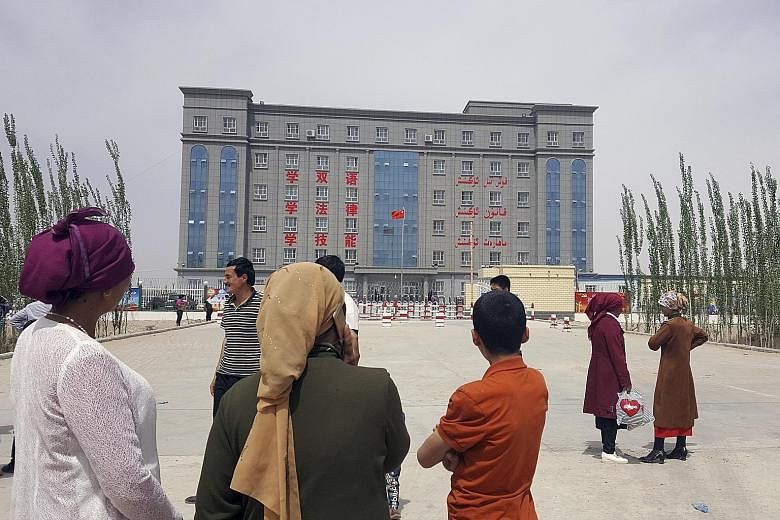 A building on the edge of Hotan, a city in Xinjiang, is described by a sign as a "concentrated transformation-through-education centre". China told a UN panel last month that it does not operate re-education camps and described the facilities in ques