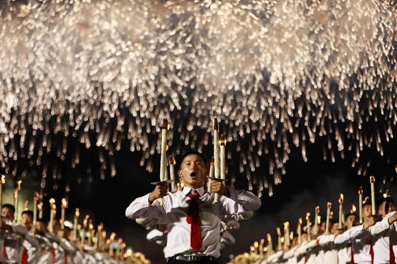 North Koreans Hold Burning Torches In Parade Marking Country's 70th ...