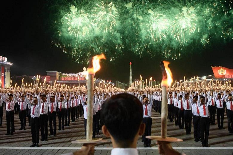 North Koreans Hold Burning Torches In Parade Marking Country's 70th ...