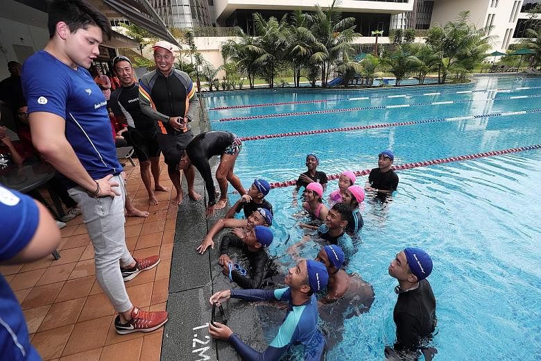 Olympic gold medallist Joseph Schooling sharing his experience with children from Care Singapore at Temasek Club yesterday.