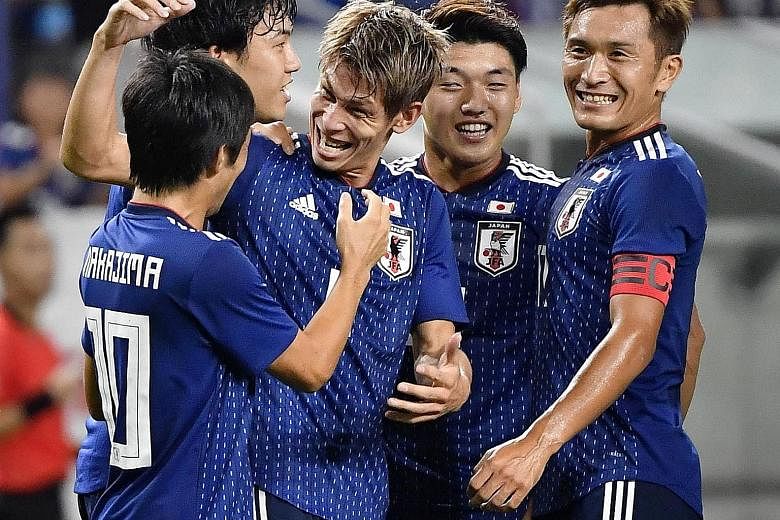 Japan defender Sho Sasaki (centre) and his team-mates celebrating their first goal against Costa Rica during their friendly in Osaka.