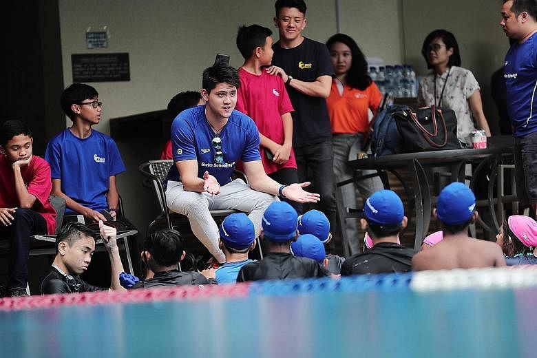 In support of the Community Chest, Joseph Schooling speaks to children at the Champion for a Good Cause swim clinic at the Temasek Club yesterday. The clinic is part of the Community Chest's 35th anniversary celebrations this year.