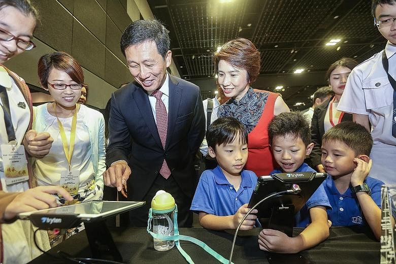 Education Minister Ong Ye Kung and Senior Parliamentary Secretary for Education and Manpower Low Yen Ling (right) checking out one of the Chinese apps that won an award in an app development contest organised by SCCL. Mr Ong gave out the awards yeste