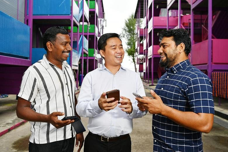 S11 Dormitories' business development director Lawrence Lee using the company's digital platform with foreign workers Nachiyappan Mohan (far left) and Khaladur Rahman Omar Ali. The platform allows residents of the firm's dormitories to give feedback 