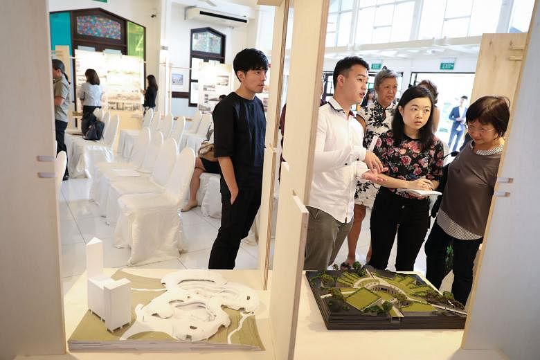 National University of Singapore architecture undergraduate John Kevin Chandra (in white), explaining his design that won the first prize in the Land For The Living - Space For The Dead design challenge yesterday. His design featured a proposed colum