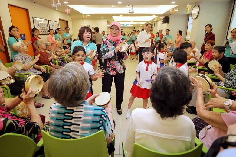 President Halimah Yacob (at centre) joined about 30 seniors and 21 kindergarten pupils at Sparkle Care @ Yew Tee for an activity-filled programme that promotes inter-generational understanding yesterday. Participants joined in with tambourines or oth