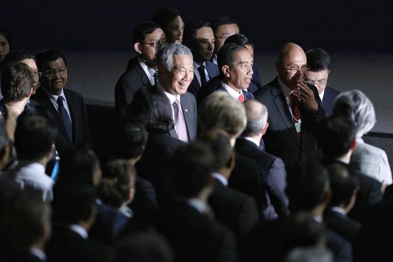 Prime Minister Lee Hsien Loong and Indonesian President Joko Widodo arriving at the National Convention Centre for the opening of the World Economic Forum in Hanoi yesterday. At the forum, PM Lee said further economic integration in Asean is an impor