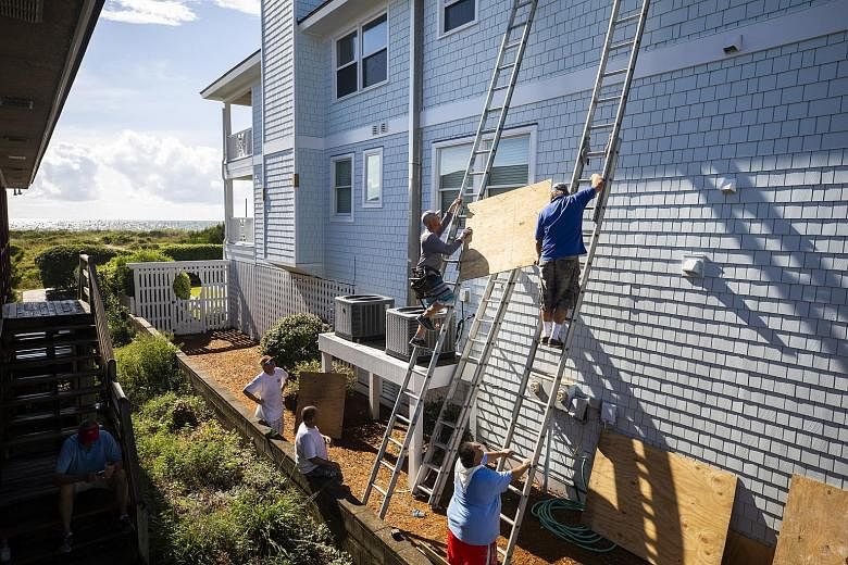Residents preparing to board up the windows of a home in North Carolina, less than two days before Hurricane Florence is expected to strike. The key to better preparedness for disasters is not to eliminate cognitive biases, but rather to design prepa