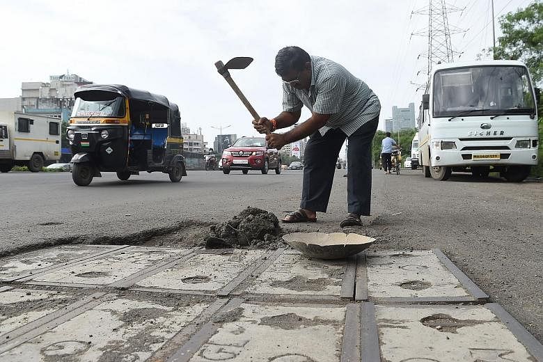 Mr Dadarao Bilhore filling up a pothole in Mumbai last month. He decided to fix the city's shoddy roads after his 16-year-old son was killed in an accident involving a pothole.