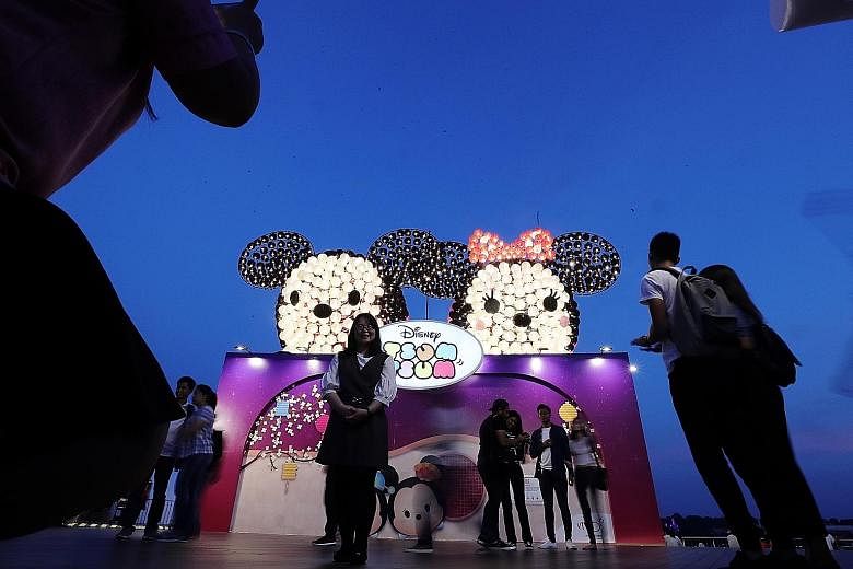 VivoCity's Sky Park: Crowds pose with Disney's Mickey and Minnie installation (left) and more than 2,000 Disney Tsum Tsum lanterns light up the night sky (right). Gardens by the Bay: The Sky Lantern Dreams at the Scented Walk (above) and The Phoenix 