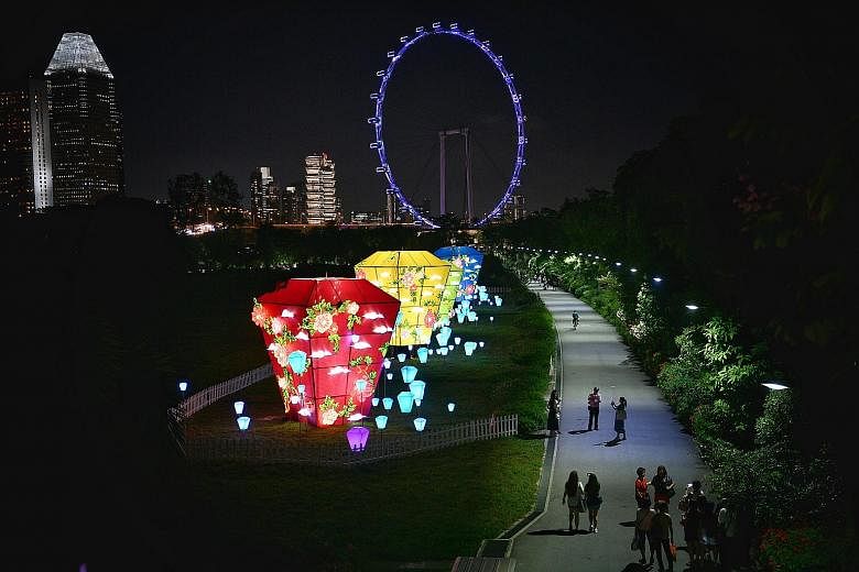 VivoCity's Sky Park: Crowds pose with Disney's Mickey and Minnie installation (left) and more than 2,000 Disney Tsum Tsum lanterns light up the night sky (right). Gardens by the Bay: The Sky Lantern Dreams at the Scented Walk (above) and The Phoenix 