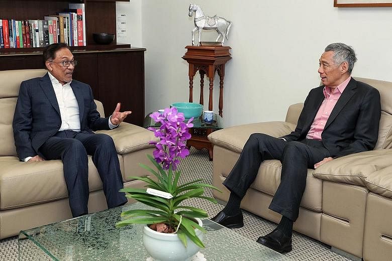 Prime Minister Lee Hsien Loong meeting Datuk Seri Anwar Ibrahim in his office yesterday.